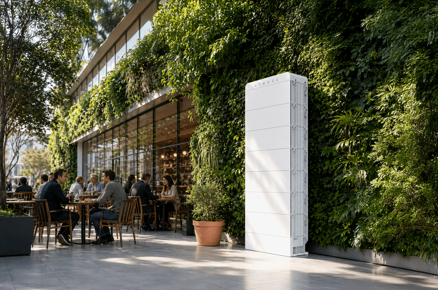 Atmoce thuisbatterij opgesteld op een terras tegen een groene plantenwand